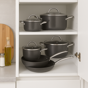 MICHELINO MARIE 7-teiliges Kochgeschirr-Set ordentlich im Küchenschrank gestapelt – stilvolle Aufbewahrung von Pfannen und Töpfen mit Glasdeckeln.