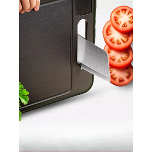 Michelino 4in1 Schneidebrett mit integriertem Messerschärfer – Messer wird am Griffbereich geschärft, daneben aufgeschnittene Tomaten.